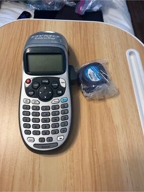 Dymo handheld label maker in silver and black with white tape